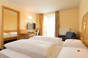 a hotel room with two beds and a window at Landhotel Huberhof in Allershausen