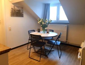 a dining room table with chairs and a vase of flowers at Het Begijnhof Tongeren Center in Tongeren +30 photos