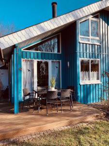 a blue house with a table and chairs on a deck at Komfort-Ferienhaus - Extertal-Ferienpark für 1-5 Personen Sauna Natur in Extertal