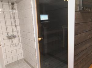 a shower with a glass door in a bathroom at Päiväkulma in Naantali
