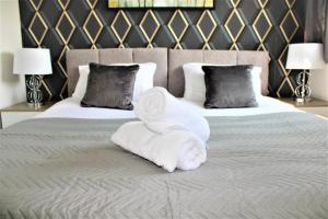 a hotel room with a bed with towels on it at Homely and Budget Friendly 3 bed house Sleeps 6 Free Parking! in Milton Keynes