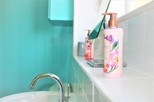 a bathroom with a bottle of lotion on a counter at Homely and Budget Friendly 3 bed house Sleeps 6 Free Parking! in Milton Keynes +16 photos