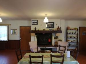 a living room with a table and chairs and a fireplace at LE CANTEGREL in Teillet