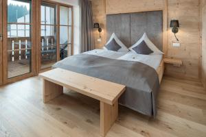 a bedroom with a large bed with a wooden wall at Seehof am Waginger See in Petting