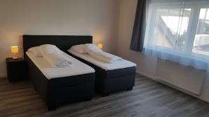 una habitación con dos camas y una ventana en Air Rooms Hotel, en Kelsterbach