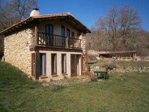 Casa de piedra con balcón en la parte superior. en Alojamientos Manzanela, en Nela