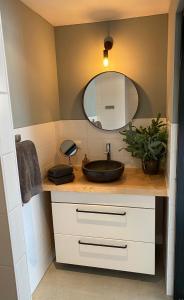 een badkamer met een wastafel en een spiegel bij Appartement de Oude School in Heerlen