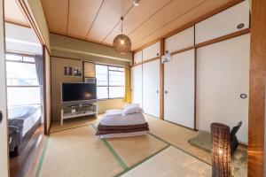 广岛SUNDAY peace room 中島 #24的带床和电视的客厅