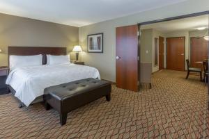 a large hotel room with a bed and a stool at Holiday Inn Eau Claire South, an IHG Hotel in Eau Claire