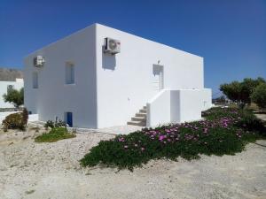 ein weißes Gebäude mit Blumen davor in der Unterkunft Hotel Perissa in Perissa