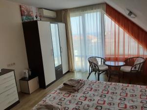 a bedroom with a bed and a table and chairs at Alexander Lozenets Beach Complex Apartment in Lozenets +30 photos