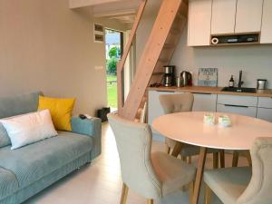 una sala de estar con un sofá y una mesa en Baltic Waterfront Yacht House - PRIVATE Garden & Watersports Included, en Świnoujście