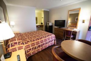 une chambre d'hôtel avec un lit et une table dans l'établissement National 9 Inn, à Buttonwillow