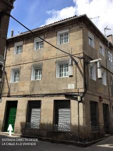 an old brick building with a green door and windows at Duplex Casco Histórico in Pontevedra