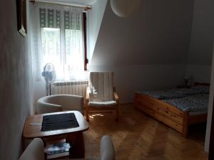 een slaapkamer met een bed, een stoel en een tafel bij Agroturystyka Józefówka Tyrawa Solna in Mrzygłód