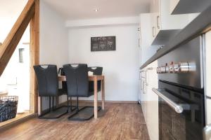 a kitchen with a table and two black chairs at Ferienwohnung Traumblick in Bernkastel-Kues