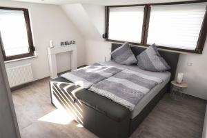 a bedroom with a bed with a blanket and two windows at Ferienwohnung Traumblick in Bernkastel-Kues