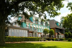 a large building with blue and white windows at Hotel Seeblick in Thülsfeld