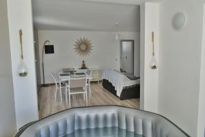 een woonkamer met een tafel en een slaapkamer bij Goldy House, logement vue mer , jacuzzi 10min port et aéroport in Baimbridge