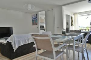 comedor y sala de estar con mesa y sillas en Goldy House, logement vue mer , jacuzzi 10min port et aéroport en Baimbridge