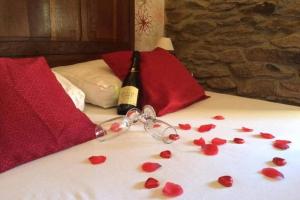 - une bouteille de vin et des coeurs rouges sur le lit dans l'établissement Vieux Logis een prachtige Ardeense vakantiewoning, à Vresse-sur-Semois