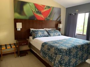 a bedroom with a bed and a painting on the wall at Jaco Sol Quadplex 11A in Jacó