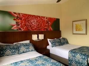 a hotel room with two beds and a painting on the wall at Jaco Sol Quadplex 11A in Jacó