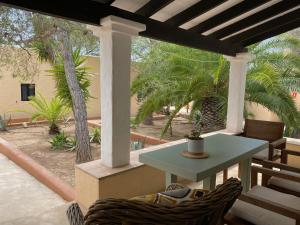 eine Terrasse mit einem Tisch und Stühlen auf einer Veranda in der Unterkunft Can Miguel Marti - Astbury Formentera in Playa Migjorn