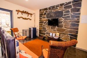 a living room with a stone wall at A Queijaria in Barreira