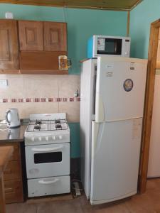 a kitchen with a white refrigerator and a stove at Casa VillaOliva in Ciudad Lujan de Cuyo