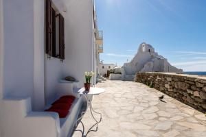 a balcony with a table and a view of the ocean at Sunset Paraportiani Rooms in Mikonos
