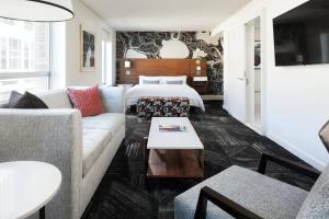 a living room with a couch and a bed at The Chambers Hotel in Minneapolis