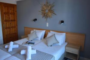 łóżko z białą pościelą i poduszkami w pokoju w obiekcie Rania Studios w mieście Skiatos