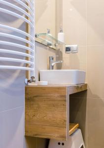 Łazienka z umywalką na drewnianym blacie w obiekcie Apartamenty-Obok 1 w Zatorze