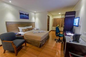 a hotel room with a bed and a desk at Fersal Hotel - Puerto Princesa in Puerto Princesa City