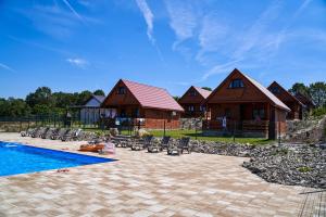 a house with a swimming pool next to a resort at Osada Łagówek - domek letniskowy do wynajęcia in Łagów