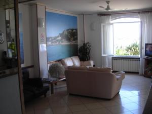 a living room with a couch and a large window at Albergo Ristorante Lucciola in Santo Stefano al Mare