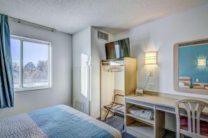 a bedroom with a desk and a bed and a window at Motel 6-Menomonie, WI in Menomonie