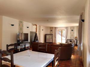 een woonkamer met een bank en een tafel bij La Belle Charbonnière in La Grande Fosse