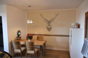 ein Esszimmer mit Tisch und Kühlschrank in der Unterkunft Apartment am Kurpark in Sankt Andreasberg + 9 Fotos