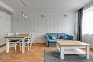 ソポトにあるLuxury Willa Morska by Grand Apartmentsのリビングルーム(青いソファ、テーブル付)