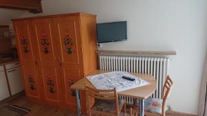 a kitchen with a table and a cabinet and a tv at Pension Tirol in San Valentino alla Muta