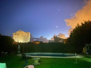 una piscina en un patio con un edificio al fondo en Carcavelos Surf Hostel & Surf Camp, en Carcavelos