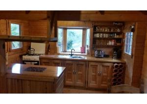 a kitchen with wooden cabinets and a sink in a cabin at Wooden Mountain Cabin in Sayalonga
