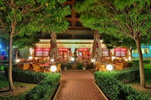 um restaurante com mesas, cadeiras e árvores à noite em Hotel Paradise Green Park Allinclusive Light em Golden Sands