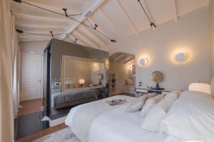 a bedroom with a large white bed and a mirror at Castellano Hotel & Suites in Nafplio