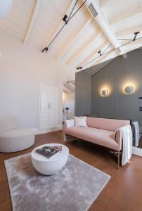 ein Wohnzimmer mit einem rosa Sofa und einem Tisch in der Unterkunft Castellano Hotel & Suites in Nafplio