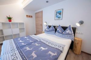 Un dormitorio con una cama con mantas y almohadas azules y blancas en Ferienwohnung Trocker en Krimml