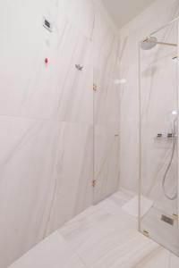 a shower with a glass door in a bathroom at Castellano Hotel & Suites in Nafplio