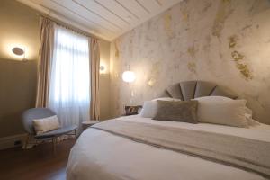 a bedroom with a large bed and a window at Castellano Hotel & Suites in Nafplio